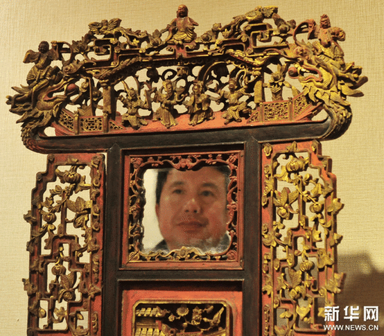 （2）2月9日，一位市民在觀看一個工藝繁復的帶鏡木雕盆架。