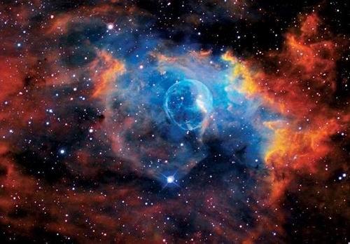 這是著名的“氣泡星云”（Bubble Nebula），這是一個(gè)灰塵氣體星云，其直徑為10光年，相當(dāng)于60萬億英里。氣泡星云是由一顆恒星燃燒時(shí)的脫離物質(zhì)構(gòu)成，恒星燃燒時(shí)可釋放出太陽數(shù)百倍亮度的光芒。該星云距離地球11000光年，位于仙后星座。