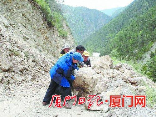 援藏干部下鄉(xiāng)調(diào)研途中遇到滾石墜落，合力將滾石推開為汽車開道。（肖衛(wèi)東 供圖）
