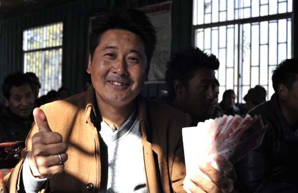崗巴村一村民領(lǐng)到生態(tài)補(bǔ)償金后，豎起大拇指夸贊黨和國(guó)家的生態(tài)環(huán)保政策 本報(bào)記者 麥正偉 攝.jpg