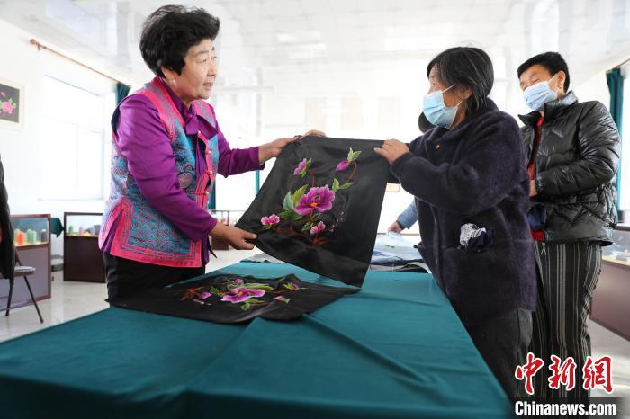圖為白晶瑩驗收繡工的作品?！】朴抑衅煨麄鞑抗﹫D