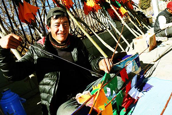 圖為：1月23日上午，來(lái)自西藏日喀則市南木林縣農(nóng)民旦增平措，在藏歷火雞新年前來(lái)山南縫制、銷(xiāo)售經(jīng)幡樹(shù)。他說(shuō)，每天可以賣(mài)出30棵左右，每棵平均賣(mài)300元至150元不等，收入可觀。曲杰 攝.jpg